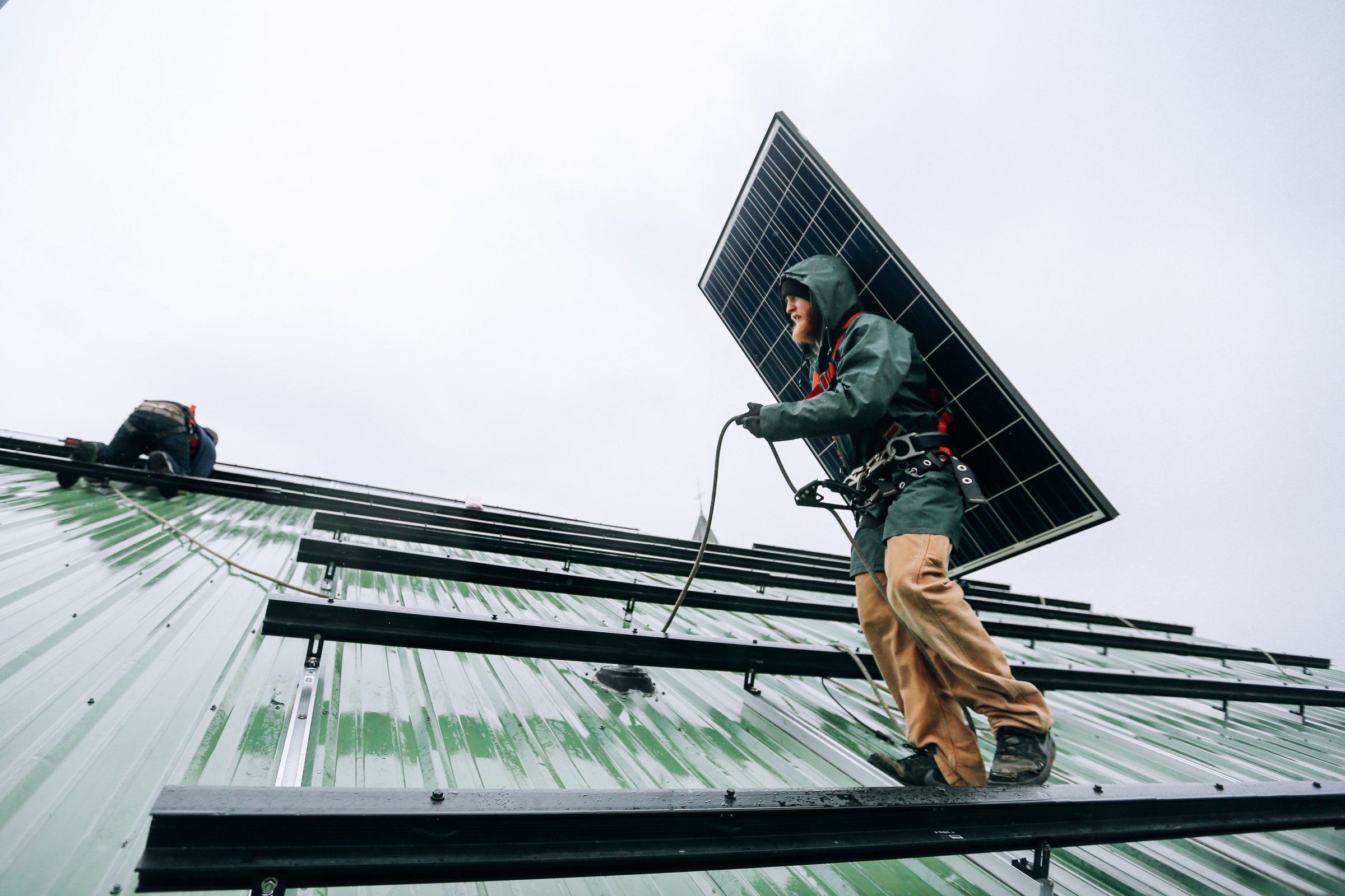 Technicians working together during a rooftop solar panel installation